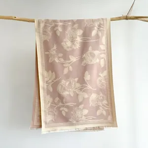 Close-up of pink rose jacquard scarf with houndstooth pattern and white tassels