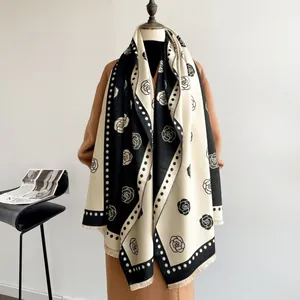 Detail of camellia jacquard scarf with contrast trim and fringe on a wool coat