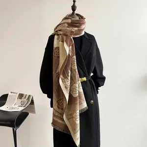 Detailed view of the brown cashmere-like shawl with vintage camellia jacquard and fringe