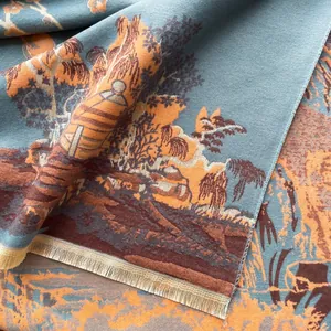 Detail of grey-blue cashmere-like scarf showing vintage landscape jacquard and golden tassels