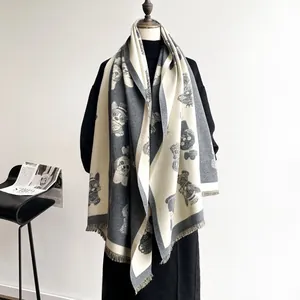Detailed view of the thick double-sided grey and white scarf with cute dog print and fringes