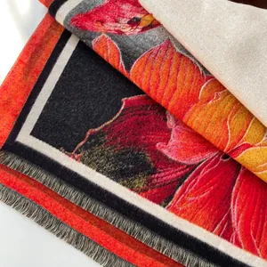 Dettaglio dello scialle in cashmere rosso a fiori con texture morbida e frange fini