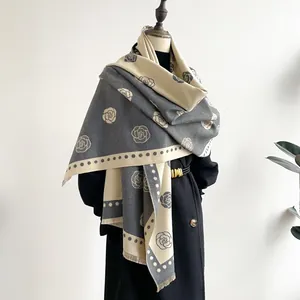 Detailed view of the camellia jacquard pattern and soft fringe on this warm shawl