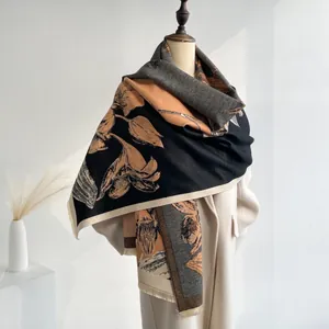 Detail shot of vintage floral thick pashmina shawl with tassel fringe on a white coat
