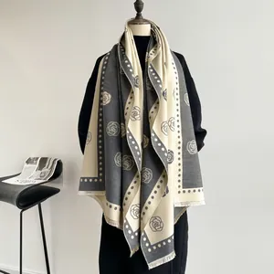 Detail of camellia jacquard scarf featuring gray and white fringe and thick cashmere feel