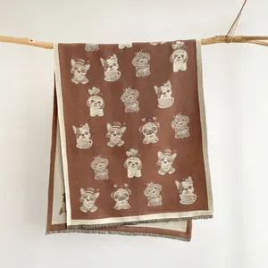 Close-up of deep brown winter scarf featuring cute cartoon dogs and fringe edge details