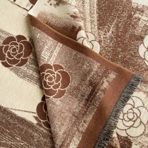 Close-up of thick cashmere-like scarf with vintage camellia floral weave and fringe