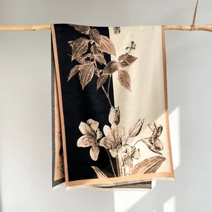 Detailed view of floral pashmina scarf texture with tassels hanging on a wood branch
