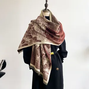 Detailed view of vintage patterned shawl with fringe tassels on a black wool coat