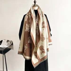 Close-up of dual-sided beige and brown cartoon dog jacquard scarf with fringe details
