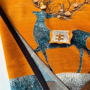 Dettaglio della sciarpa in cashmere invernale con motivo alce e trama tessuta