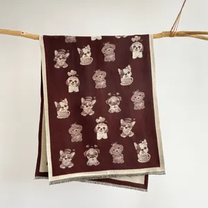 Close-up of cute cartoon dog patterns on soft burgundy and beige knit cashmere shawl
