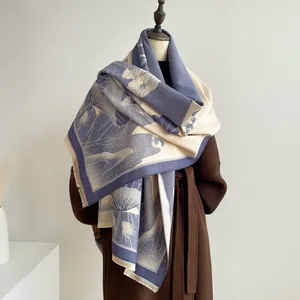 Close-up of jacquard floral pattern and fine tassels on thick navy blue winter shawl