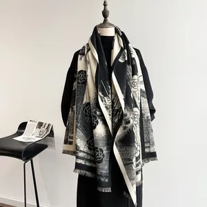 Thick black and white cashmere-like scarf with camellia patterns and soft fringe trim