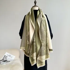 Detail of floral patterns and fringe on green cashmere-like shawl wrap for winter