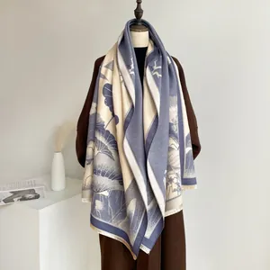 Detail of blue and beige jacquard scarf with lotus pattern and fine fringed edges