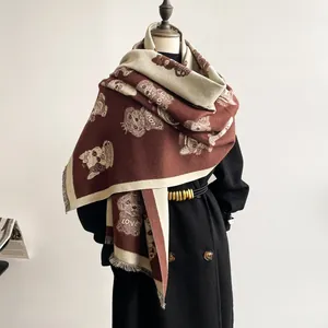 Close-up of thick scarf showing cute bear pattern and 'LOVE' text with tassel fringe