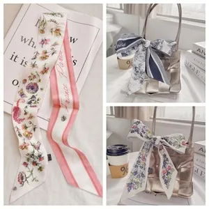 Detail van bloemen zijden sjaal geknoopt aan een tas met retro Franse Parijs print