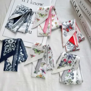 Flat lay of six floral printed satin scarves with vintage patterns on a white texture background