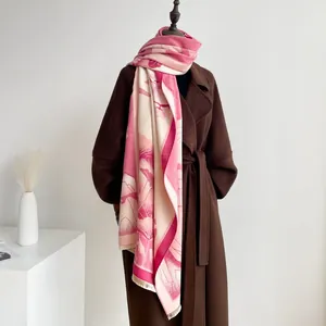 Detailed shot of pink and beige jacquard scarf with floral patterns and fringe edges