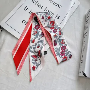 Detail of red floral satin ribbon scarf with butterfly print on marble surface