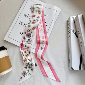 Floral skinny scarf with France Paris script next to fashion magazines and coffee