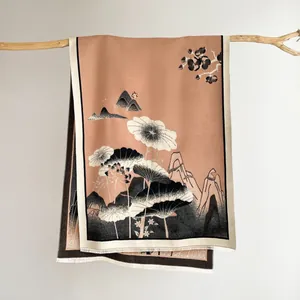 Detail of pink silk scarf with ink lotus landscape print and fringe edges on wood