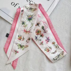 Detailed macro view of the floral satin twilly scarf showing polyester material and labels