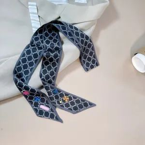 Detail view of black geometric chain print silk scarf on office suit and coffee backdrop