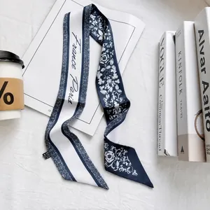 Detail of navy blue silk scarf with white floral pattern and France Paris text