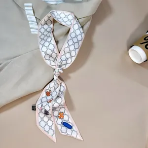 Elegant chain pattern silk scarf tied on a designer handbag with chic fashion styling