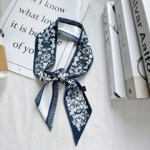 Close-up of a dark blue floral skinny silk scarf with elegant Vogue and Kinfolk styling