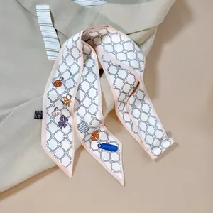 Elegant narrow silk-like scarf with geometric chain and floral patterns on a blazer