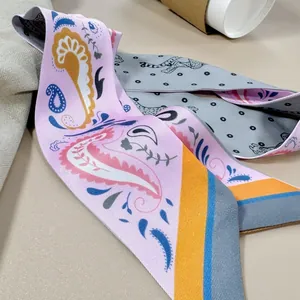 Detail of double-sided paisley and leopard print silk scarf tied elegantly on a bag