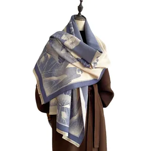 Blue and beige jacquard floral shawl scarf styled on a brown winter wool coat