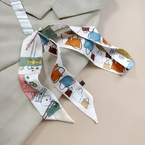 Close-up of a double-layered silk scarf with colorful handbag prints on a beige blazer