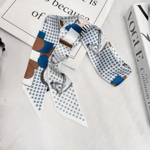 Detailed view of British equestrian style narrow silk scarf with horse pattern on white fabric