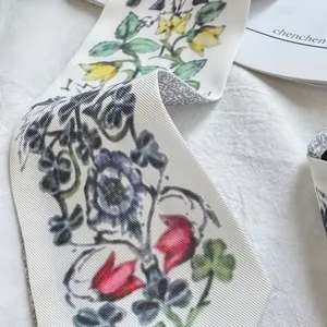 Detailed view of floral pleated satin skinny scarf on a lifestyle magazine background