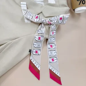 Detail van een zijdeachtige bedrukte sjaal geknoopt in een strik op kaki kleding