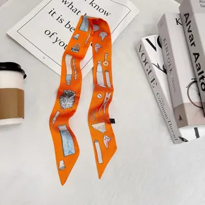 Vista dettagliata di un foulard in seta arancione con motivi di piume fatti a mano