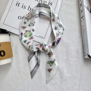 Close-up of a floral skinny scarf with butterfly patterns and geometric grey borders