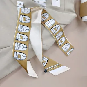 Elegante mosterdgele zijden sjaal met belletjesprint op een beige kostuumjasje