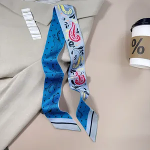 Detailed close-up of double-sided silk scarf with leopard and paisley patterns on a beige coat