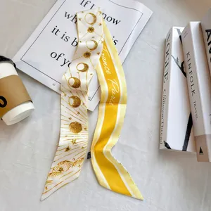 Detailed shot of yellow floral skinny silk scarf with Paris letters and celestial patterns