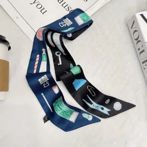 Dettaglio foulard in seta twilly con motivi di cancelleria su sfondo di marmo bianco