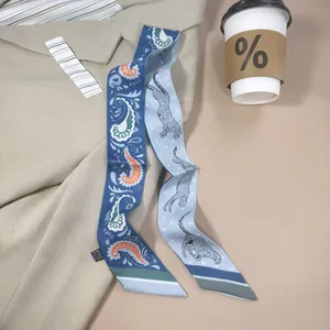 Detail of paisley and leopard print silk-feel twilly scarf styled on a beige blazer