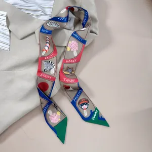 Detail eines bunten bedruckten Seidenschals mit Cartoon-Illustrationen auf beigem Blazer