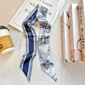 Detail of navy blue French floral twilly scarf with Paris print on lifestyle background