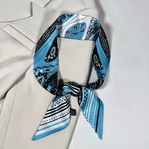 Dettaglio di una lunga sciarpa twilly blu a motivi paisley su un blazer