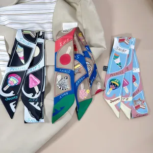Drei Twilly-Seidenschals mit Cartoon-Prints auf einem beigen Blazer und gestreiftem Top